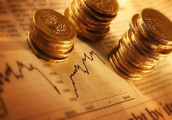 Stacks of gold coins placed on financial charts with a warm golden glow, representing investment and market trends.